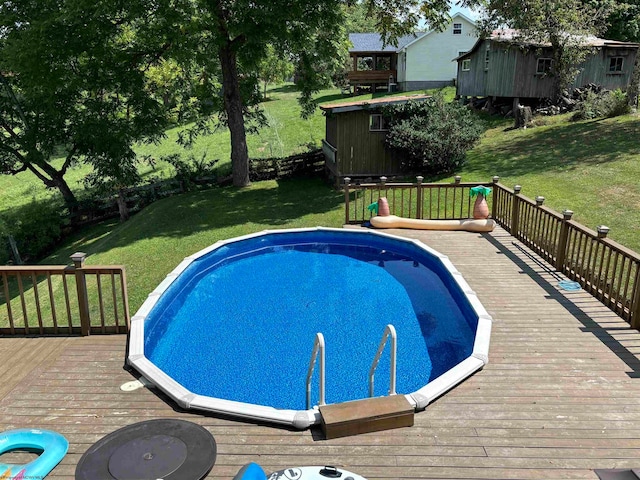 view of swimming pool featuring a wooden deck and a yard