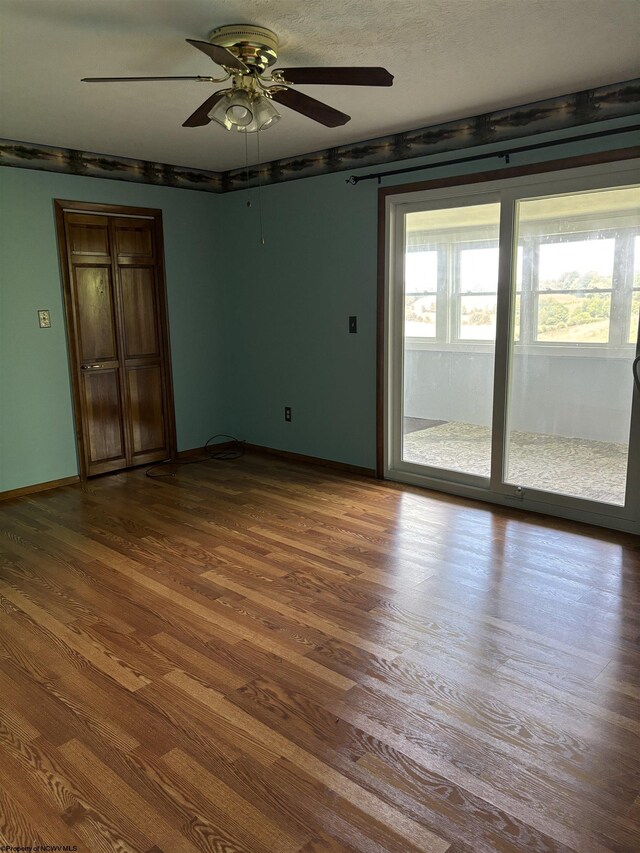 unfurnished room with ceiling fan and wood-type flooring