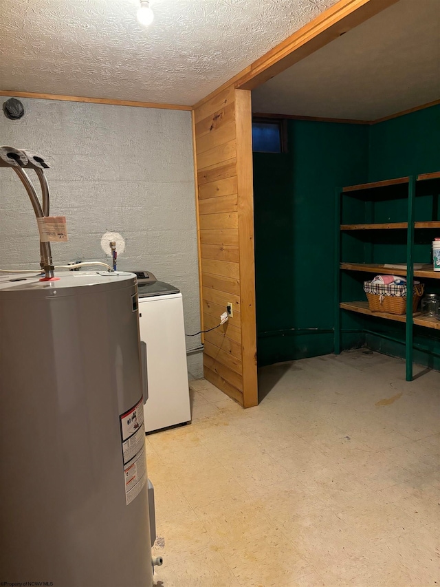 washroom with electric water heater, a textured ceiling, wood walls, and washer and dryer