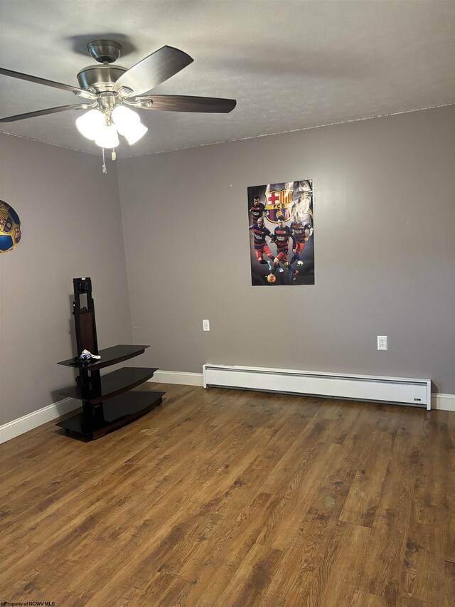 empty room featuring ceiling fan, a baseboard radiator, and wood-type flooring