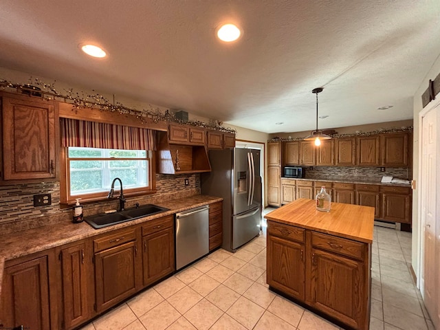 kitchen featuring decorative backsplash, appliances with stainless steel finishes, light tile patterned floors, sink, and butcher block counters