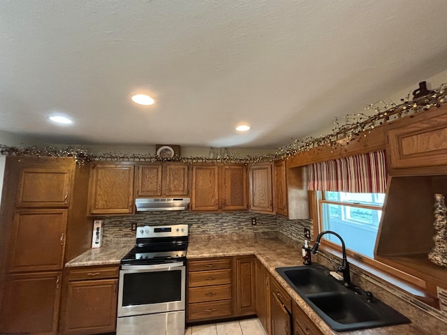 kitchen featuring light tile patterned floors, stainless steel electric stove, tasteful backsplash, and sink