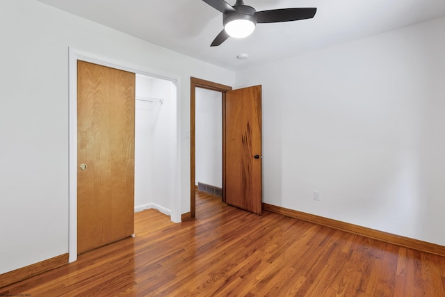 unfurnished bedroom featuring ceiling fan, a closet, and hardwood / wood-style flooring