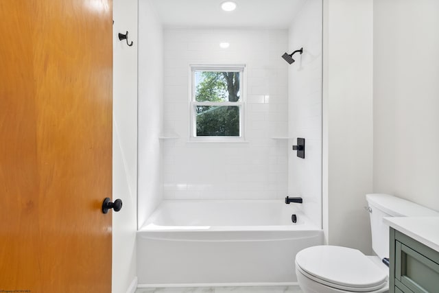 full bathroom featuring vanity, tiled shower / bath, and toilet