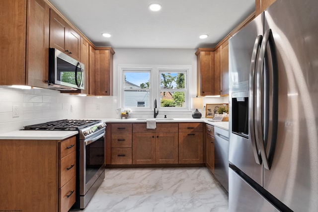 kitchen featuring sink, stainless steel appliances, backsplash, and light tile patterned floors