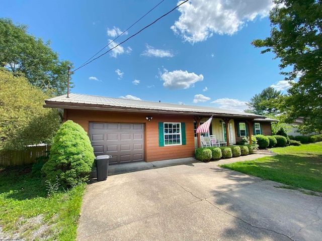 view of front of home with a front lawn, a porch, and a garage