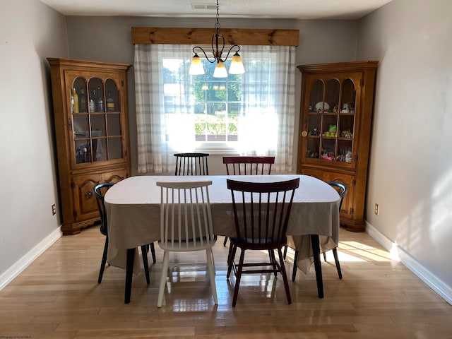 dining space featuring an inviting chandelier and light hardwood / wood-style floors