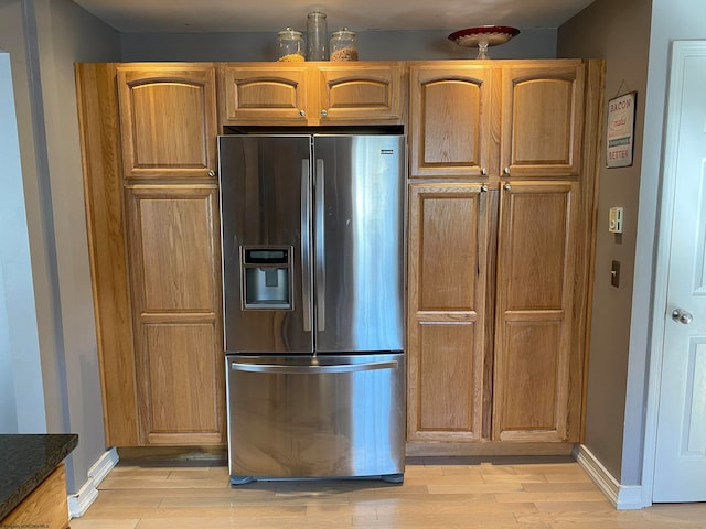 kitchen with light hardwood / wood-style flooring and stainless steel fridge