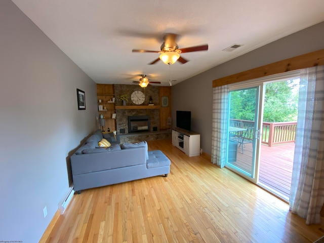 living room with ceiling fan, light hardwood / wood-style flooring, and a fireplace