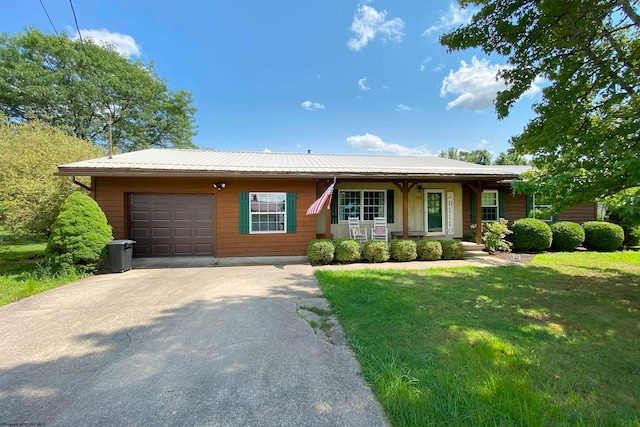 view of front of property featuring a garage, a front yard, and a porch