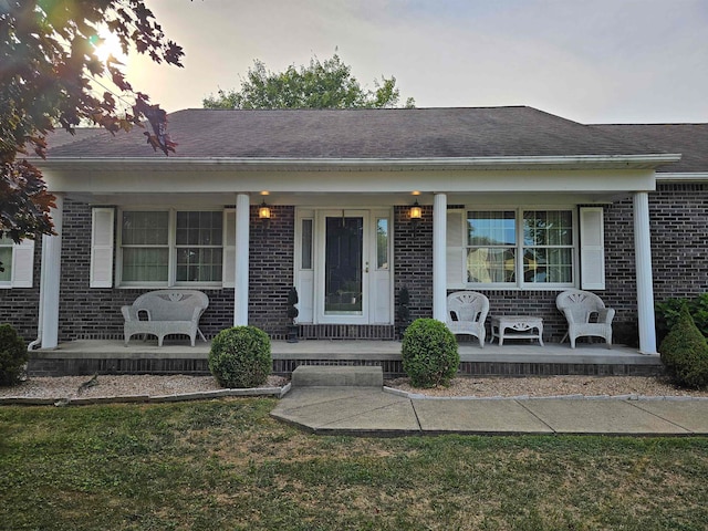 view of front of property with covered porch and a lawn