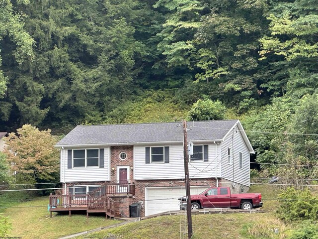 split foyer home with a deck, a garage, and a front yard