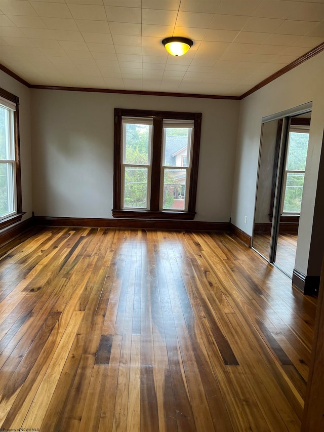 unfurnished room with hardwood / wood-style flooring and crown molding