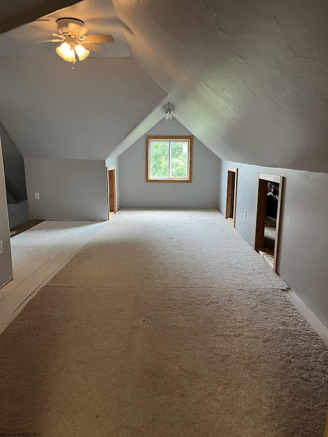 bonus room with ceiling fan, light carpet, and vaulted ceiling