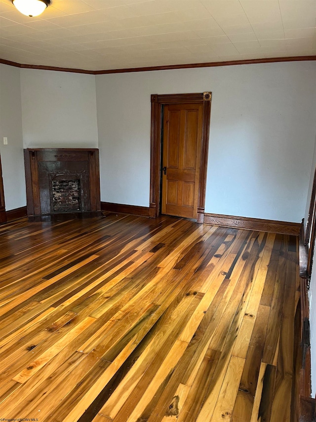 unfurnished living room featuring dark hardwood / wood-style flooring and crown molding