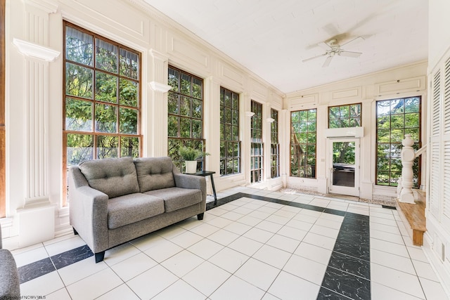 sunroom featuring ceiling fan and decorative columns