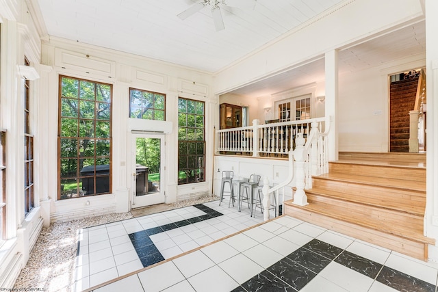 unfurnished sunroom with ceiling fan