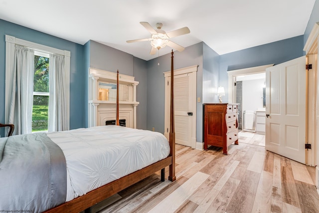 bedroom featuring light hardwood / wood-style floors, ceiling fan, a closet, and ensuite bath