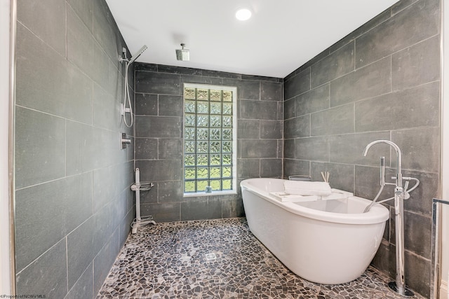 bathroom with a bath, radiator heating unit, tile patterned flooring, and tile walls