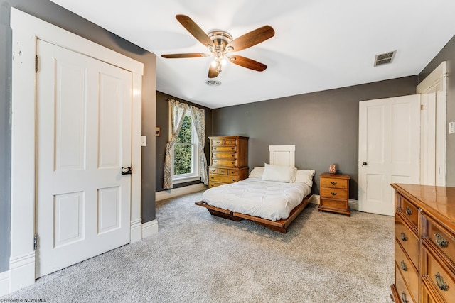 bedroom featuring ceiling fan, light carpet, and a closet