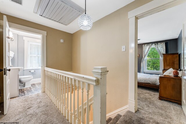 hallway with hardwood / wood-style flooring and a notable chandelier