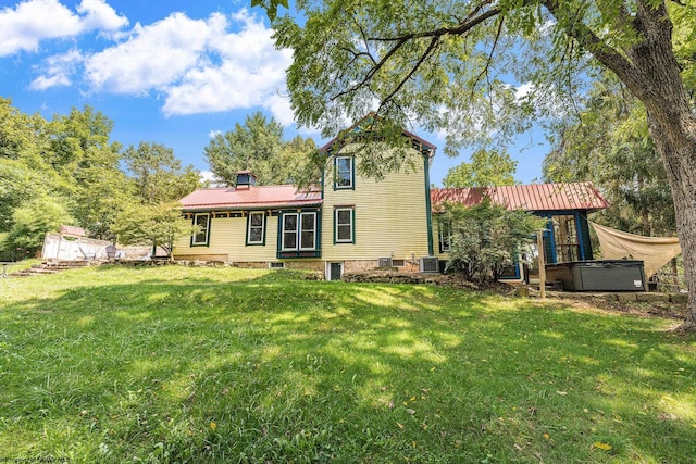 back of house featuring central AC and a yard