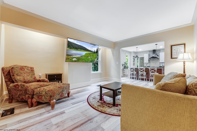 living room with light hardwood / wood-style flooring and ornamental molding