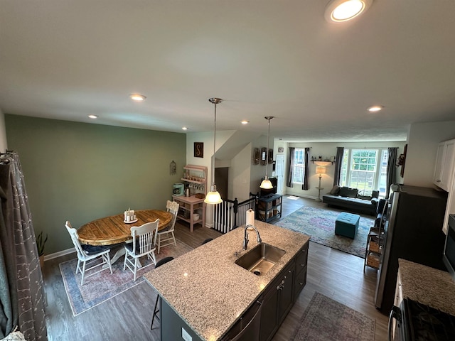 kitchen with a kitchen island with sink, sink, pendant lighting, and dark hardwood / wood-style floors