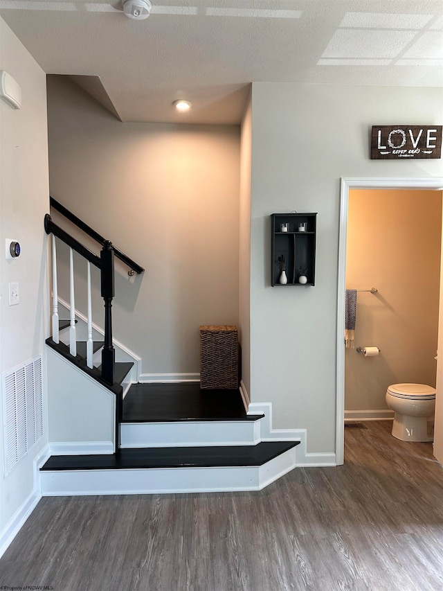 staircase with hardwood / wood-style floors