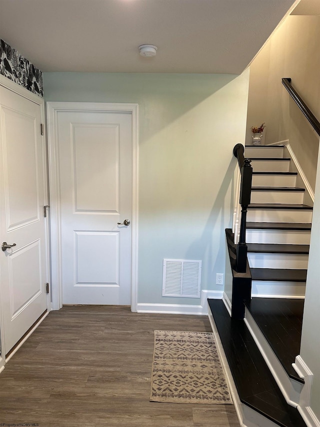 staircase with hardwood / wood-style floors