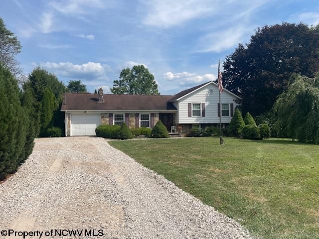 split level home featuring a garage and a front lawn