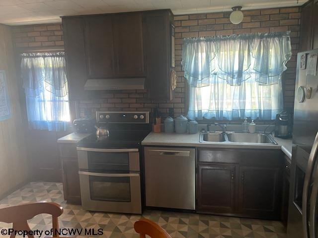 kitchen with ventilation hood, plenty of natural light, sink, and stainless steel appliances