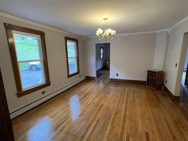 spare room featuring crown molding, wood finished floors, baseboards, a baseboard heating unit, and an inviting chandelier