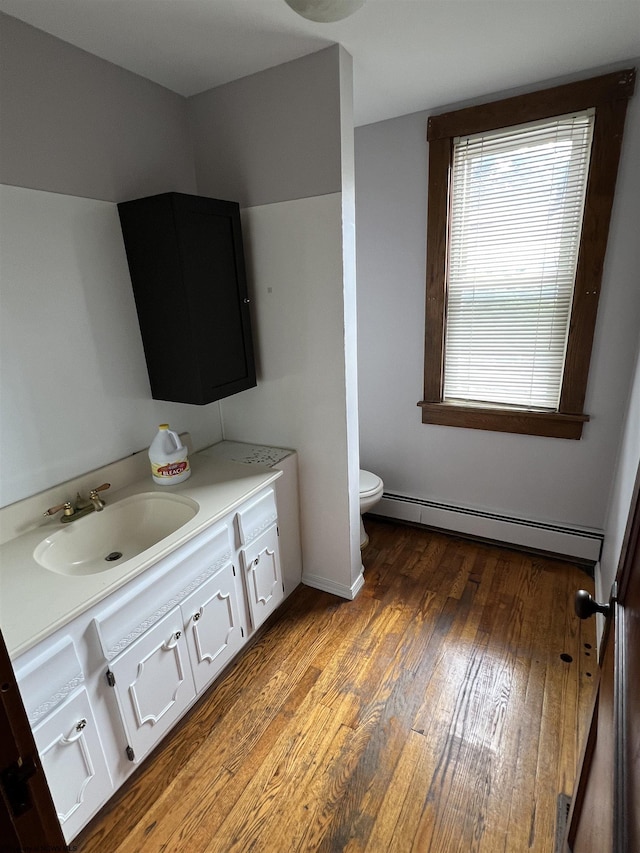bathroom featuring a baseboard radiator, toilet, vanity, and hardwood / wood-style floors