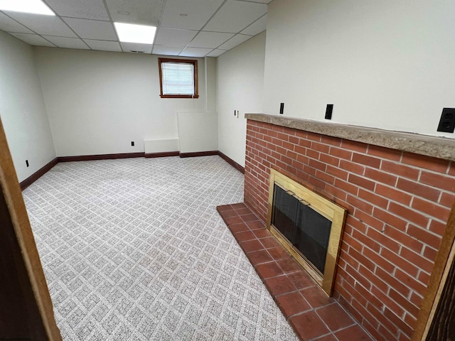 interior space with carpet, a fireplace, and a drop ceiling