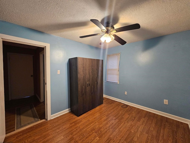 unfurnished bedroom with hardwood / wood-style floors, ceiling fan, and a textured ceiling