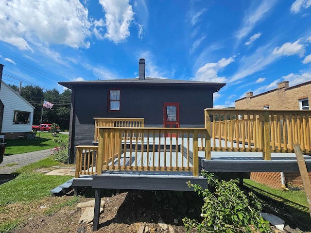 rear view of house featuring a wooden deck