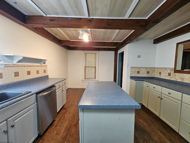 kitchen featuring stainless steel dishwasher, beamed ceiling, dark countertops, and a center island