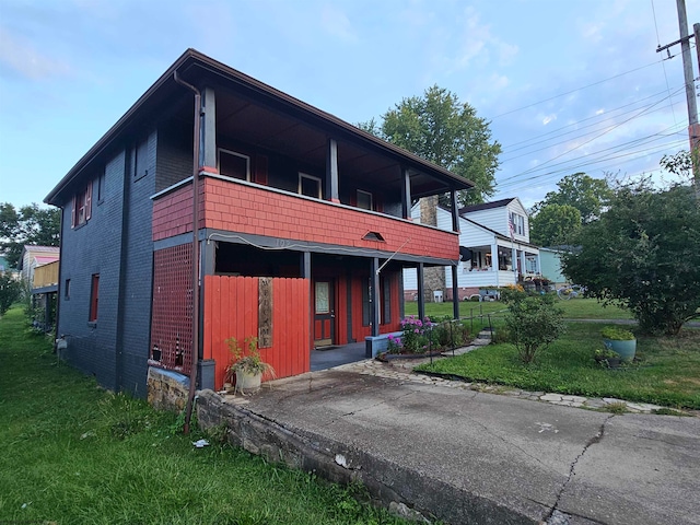 exterior space featuring a balcony and a front yard