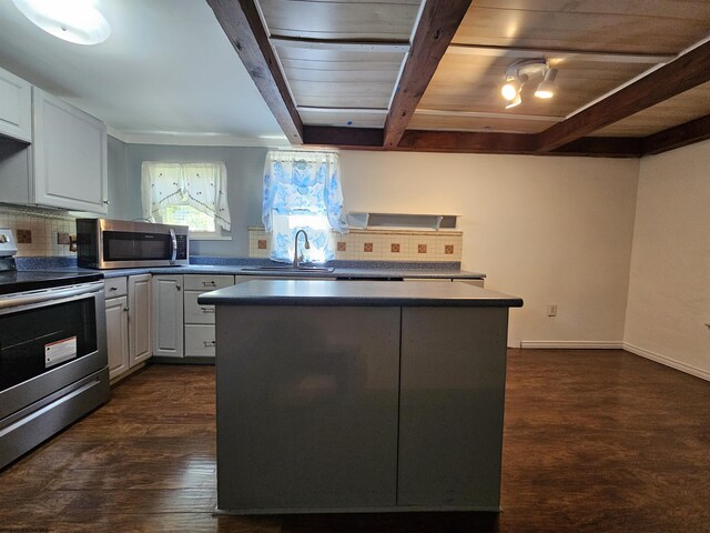 kitchen featuring stainless steel appliances, decorative backsplash, a center island, and beam ceiling