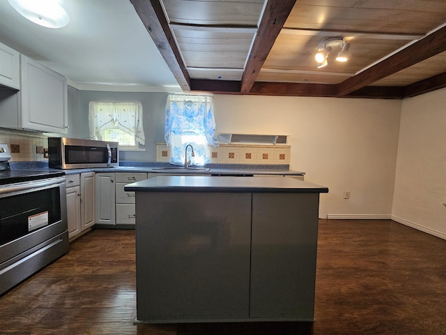 kitchen with appliances with stainless steel finishes, a kitchen island, and white cabinetry