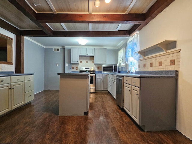 kitchen with dark wood finished floors, stainless steel appliances, dark countertops, a kitchen island, and beamed ceiling