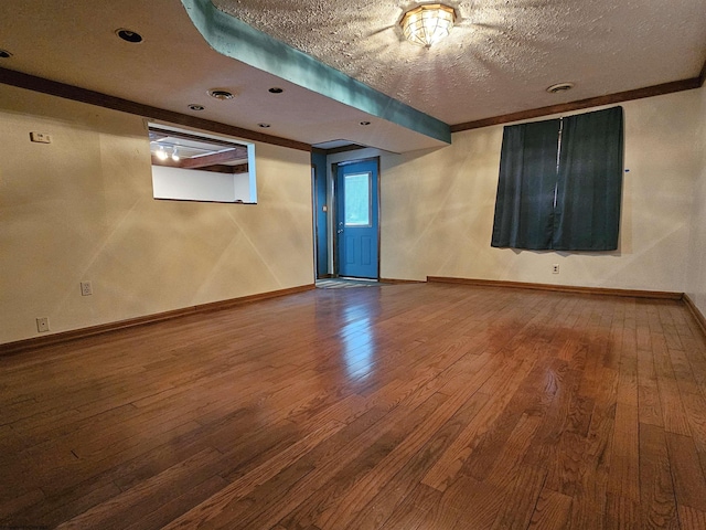 empty room featuring visible vents, a textured ceiling, baseboards, and wood finished floors