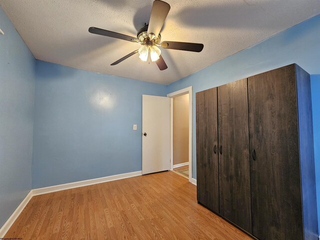 unfurnished bedroom featuring ceiling fan, a textured ceiling, and light hardwood / wood-style floors