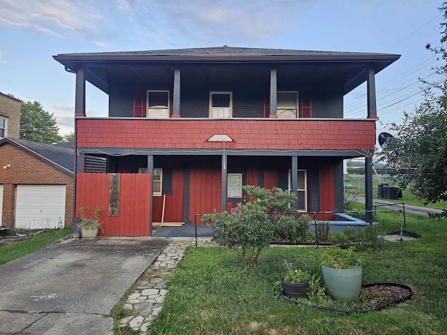 view of front of property featuring a garage, a front yard, covered porch, and a balcony