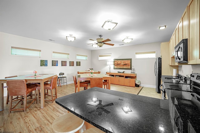 kitchen with appliances with stainless steel finishes, light hardwood / wood-style flooring, ceiling fan, and light brown cabinets