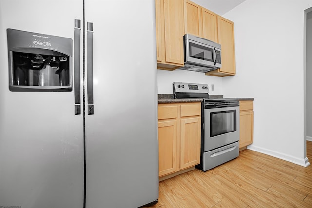 kitchen with light brown cabinets, light hardwood / wood-style flooring, and stainless steel appliances