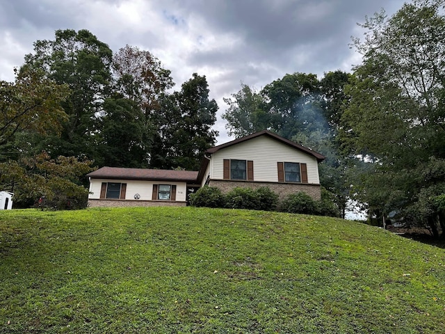 tri-level home featuring brick siding and a front lawn