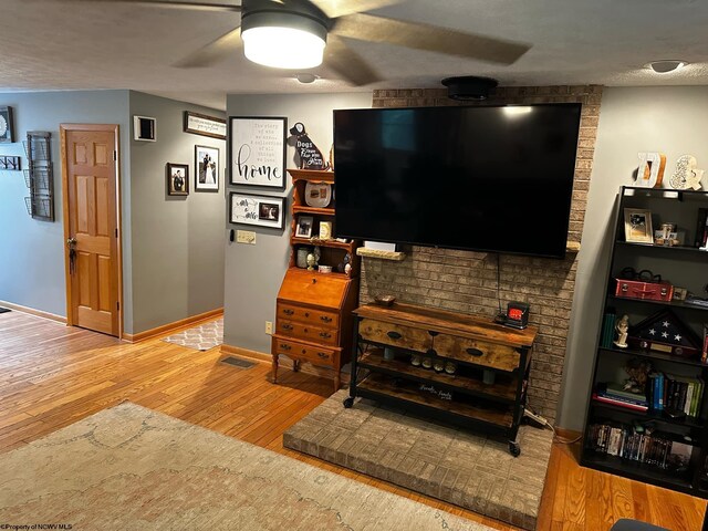 living room featuring ceiling fan and light hardwood / wood-style floors