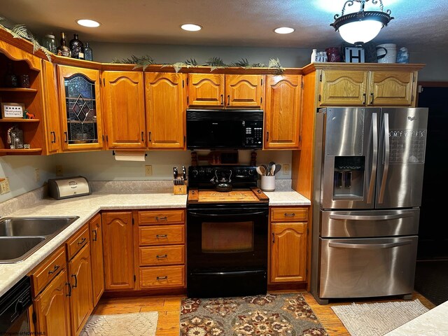 kitchen featuring sink, light hardwood / wood-style flooring, and black appliances